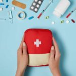 a first aid kit in the hands of a woman.