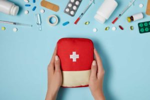 a first aid kit in the hands of a woman.